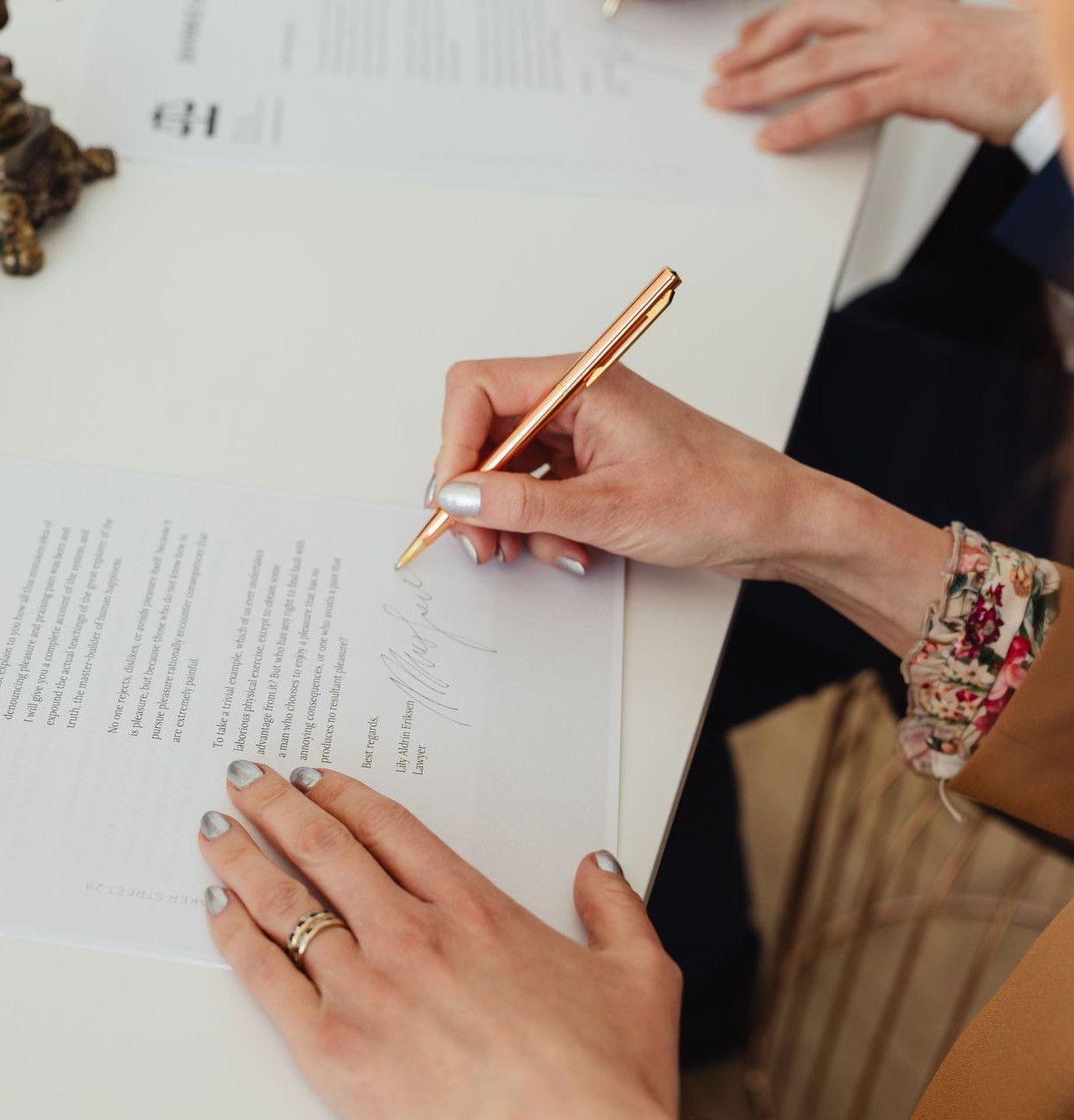 Close-up of hands signing a divorce decree document on a desk, showcasing legal process.